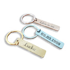 Tri gravírované kľúčenky v zlatej, striebornej a medenej farbe na bielom pozadí